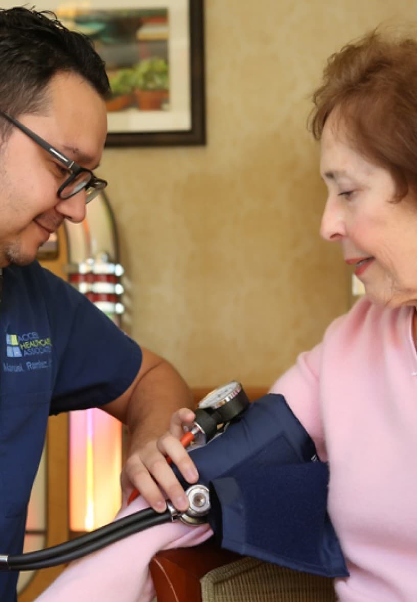 An Access Healthcare Associates clinician taking a resident's blood pressure